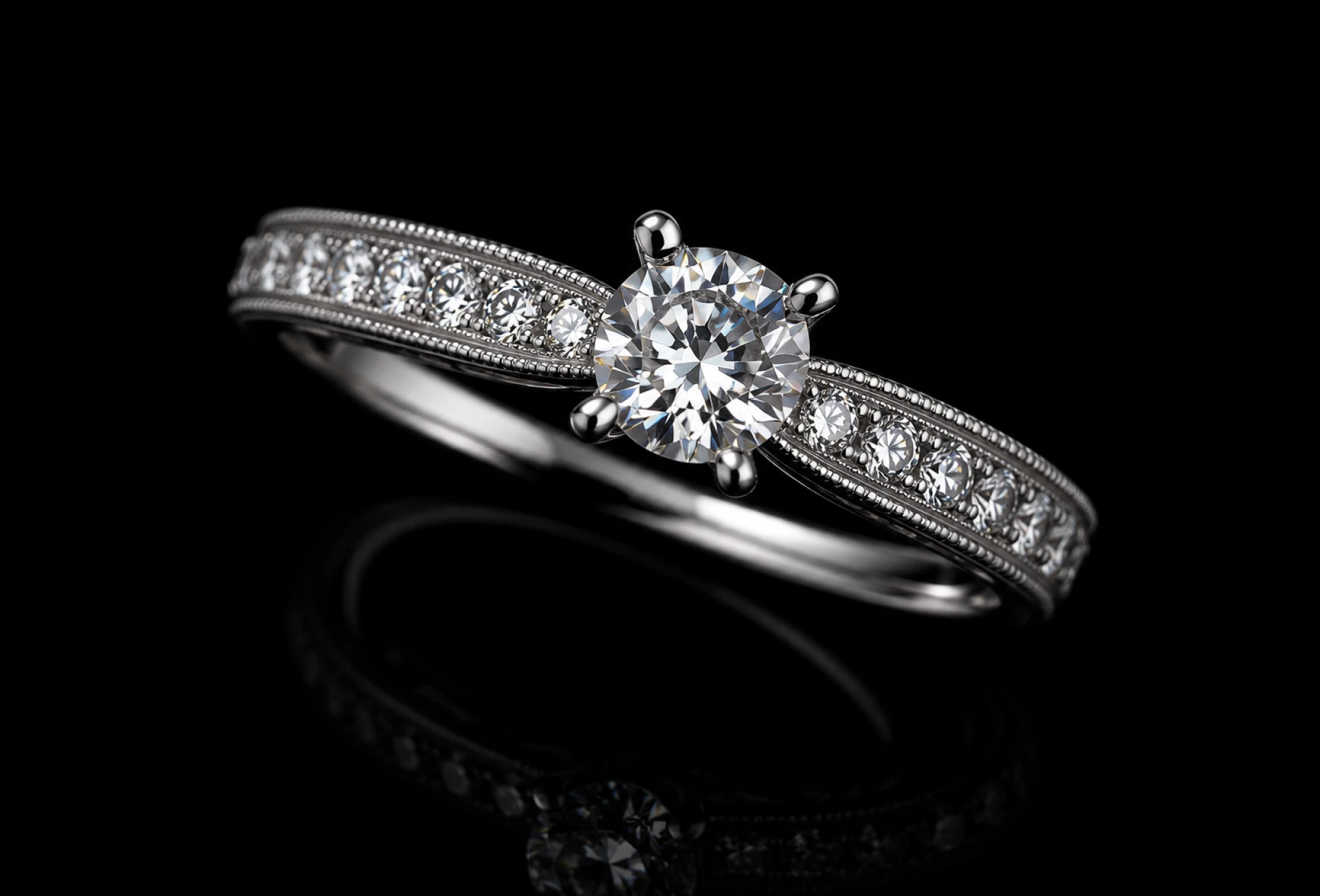Diamond engagement ring on black reflective surface.